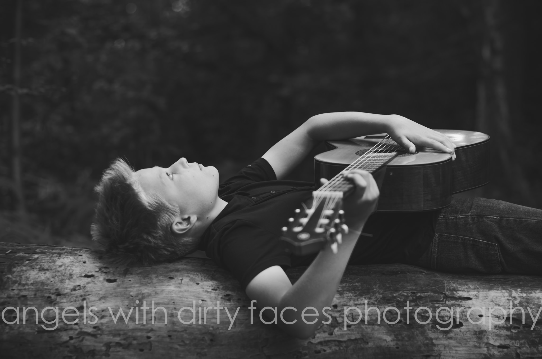 a boy plays his guitar in the welwyn garden city woodland