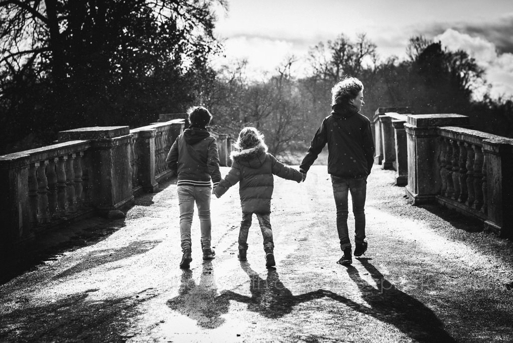three brothers walk in the wind over a bridge in hertfordshire