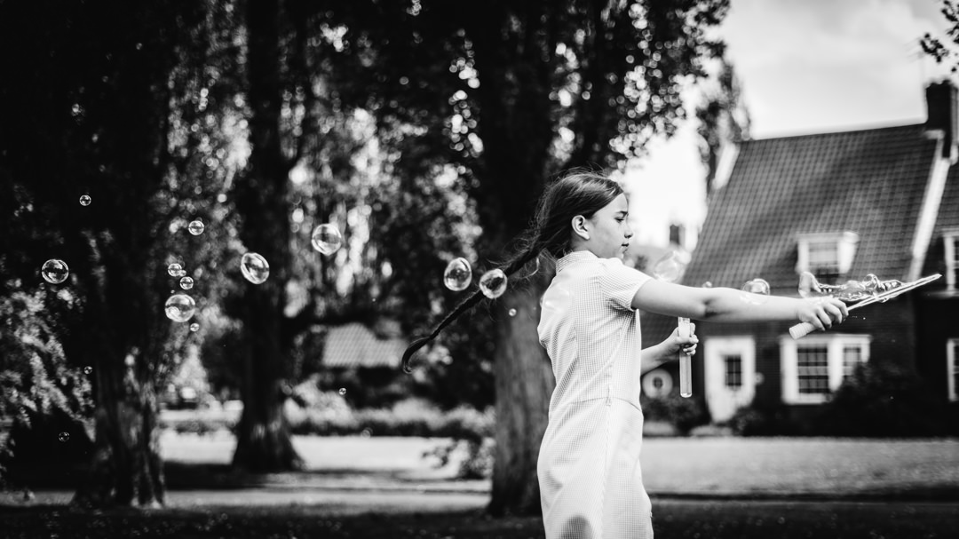 young girl plays with bubbles