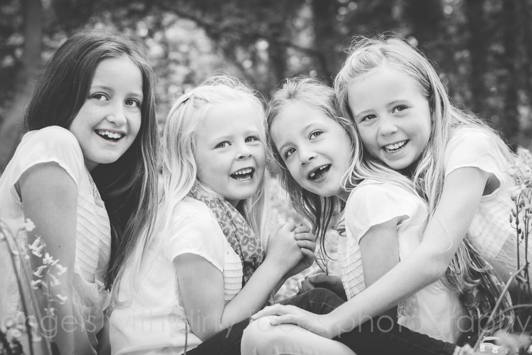 giggling cousins huddle together in the welwyn garden woods for their photography session 
