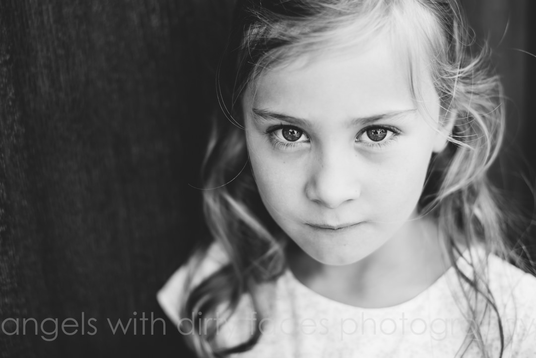 beautiful little girl looks straight into photography lens for her family photography