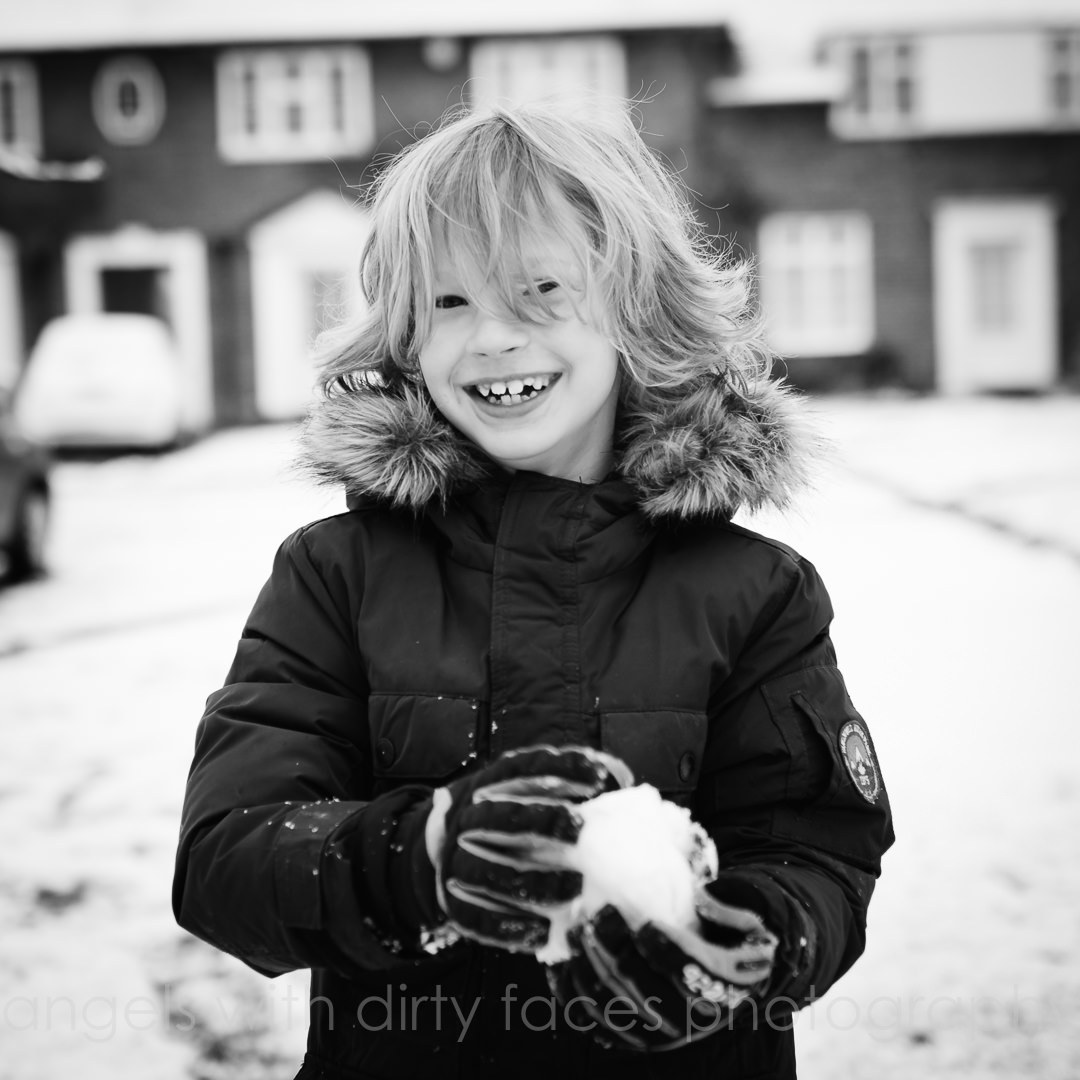 smiling child plays in the snow