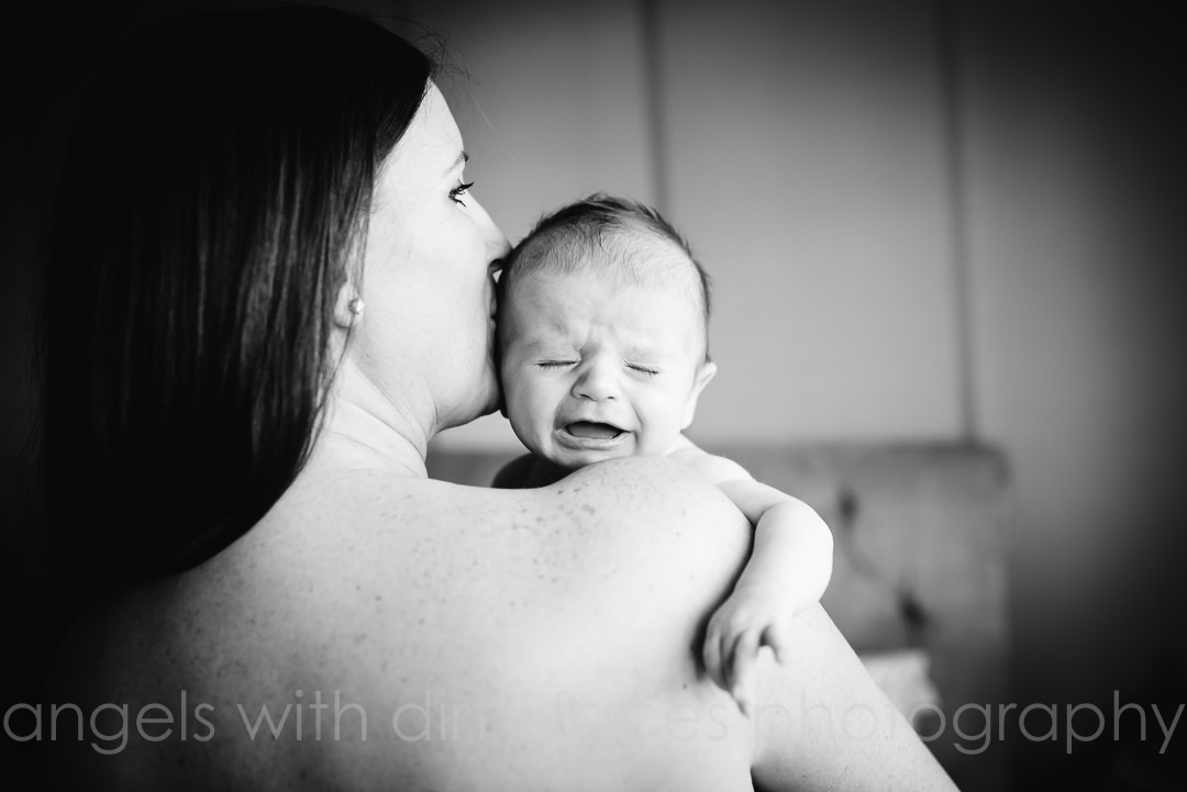 Hertford crying baby looks over mums shoulder  during  Photo Shoot At Home