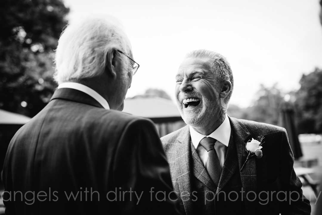 groom laughs with his new father in law at hertfordshire wedding