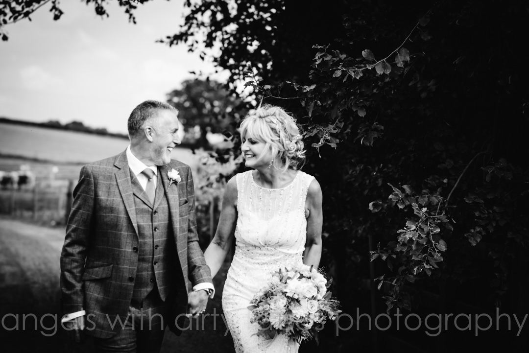bride and groom walk through the grounds of tewin bury farm 