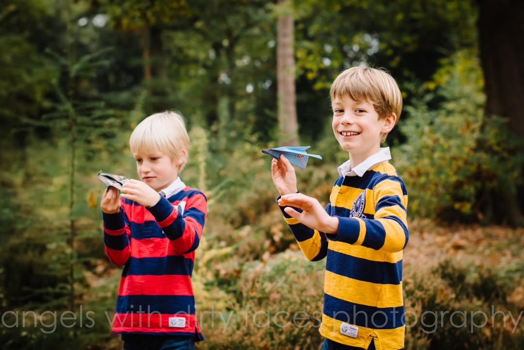 brothers play with paper airplanes in welwyn garden city woods