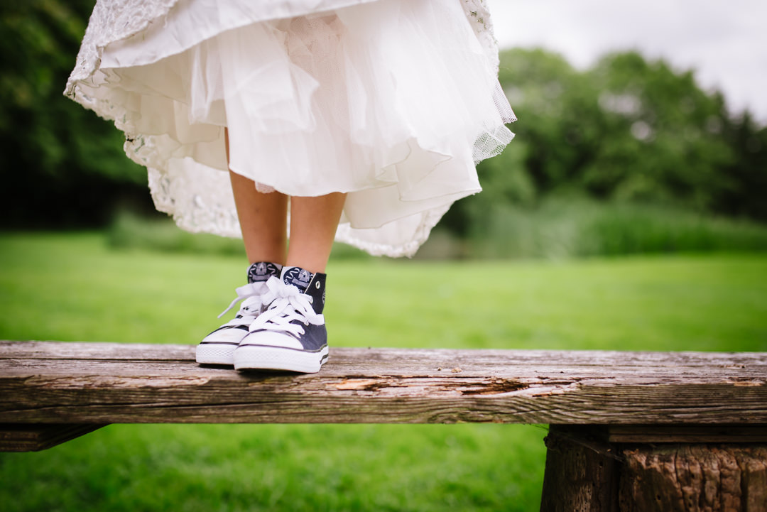 Child Bridesmaid shows off her converse shoes at Hertfordshire wedding