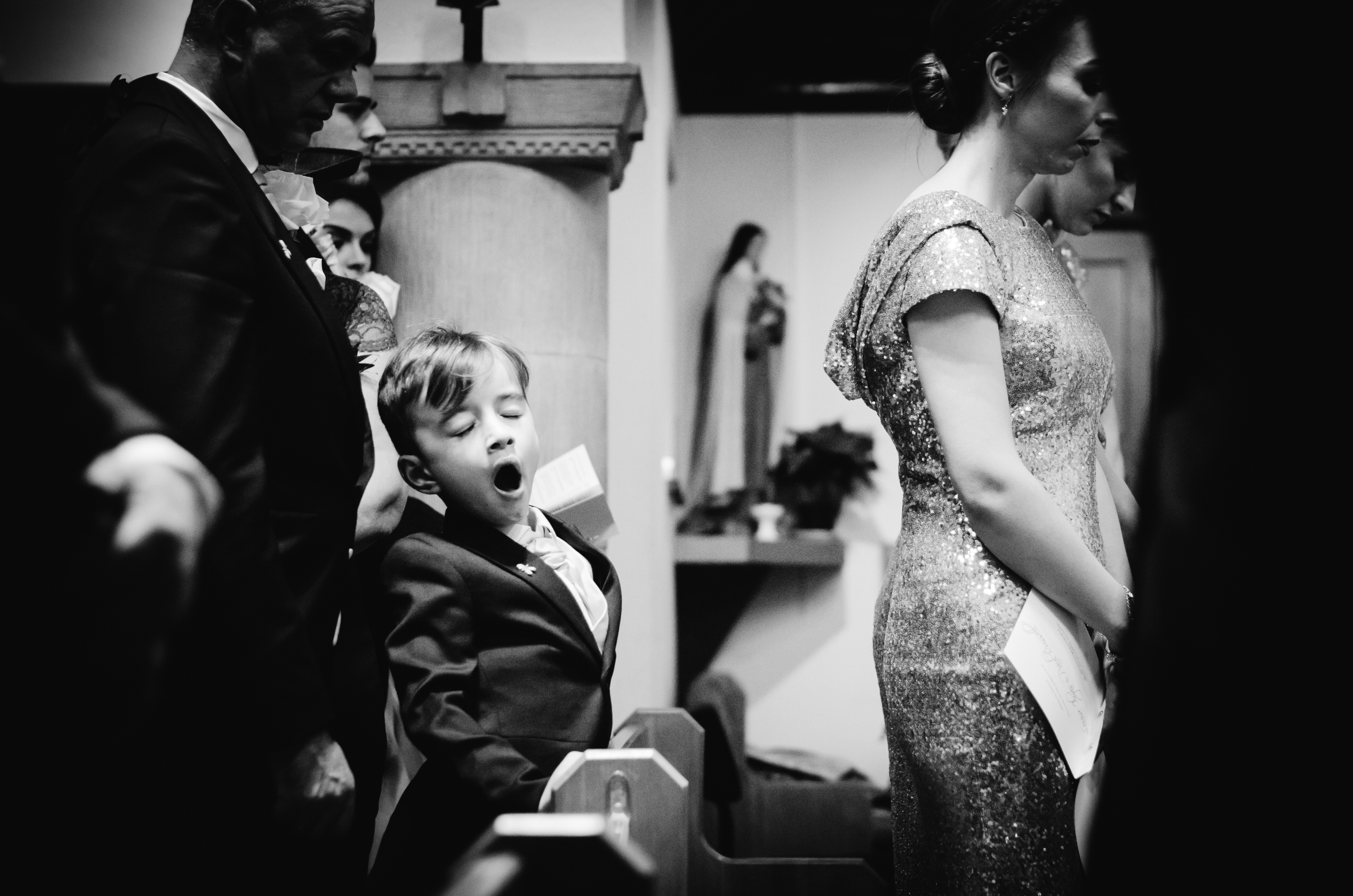 Hertfordshire Wedding Photographer documents child yawning at a Wedding ceremony 
