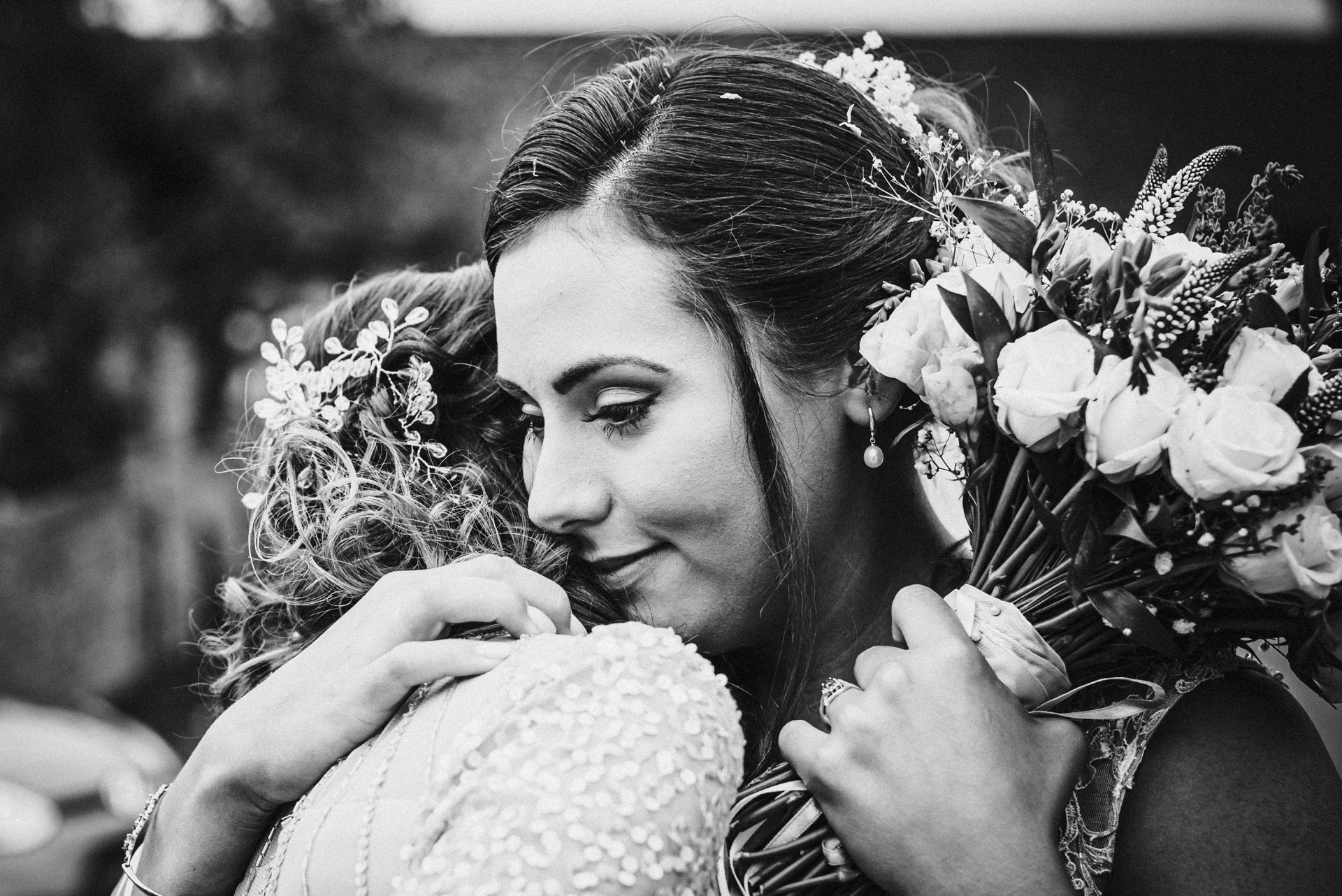 Bride tenderly hugs her bridesmaid at Milling Barn