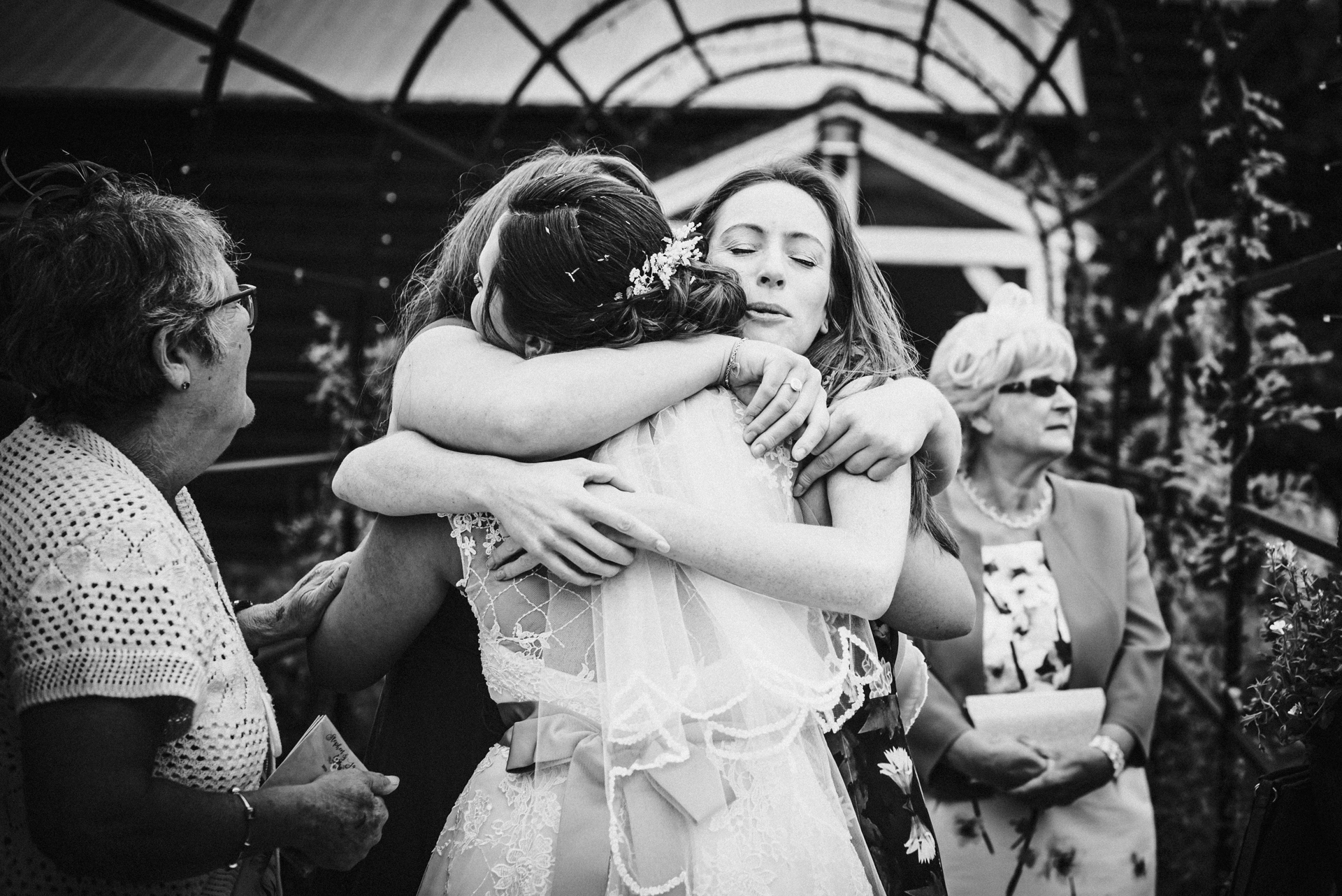 Wedding guests hug the bride