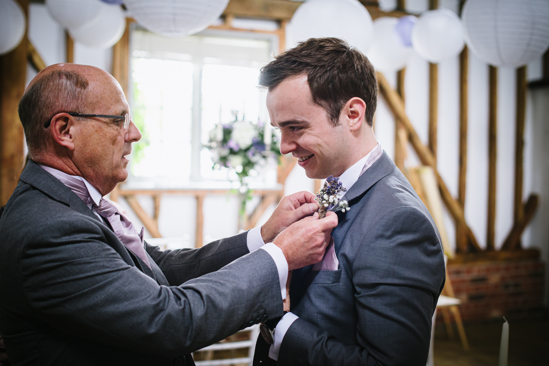best man puts on his button hole before the milling barn wedding