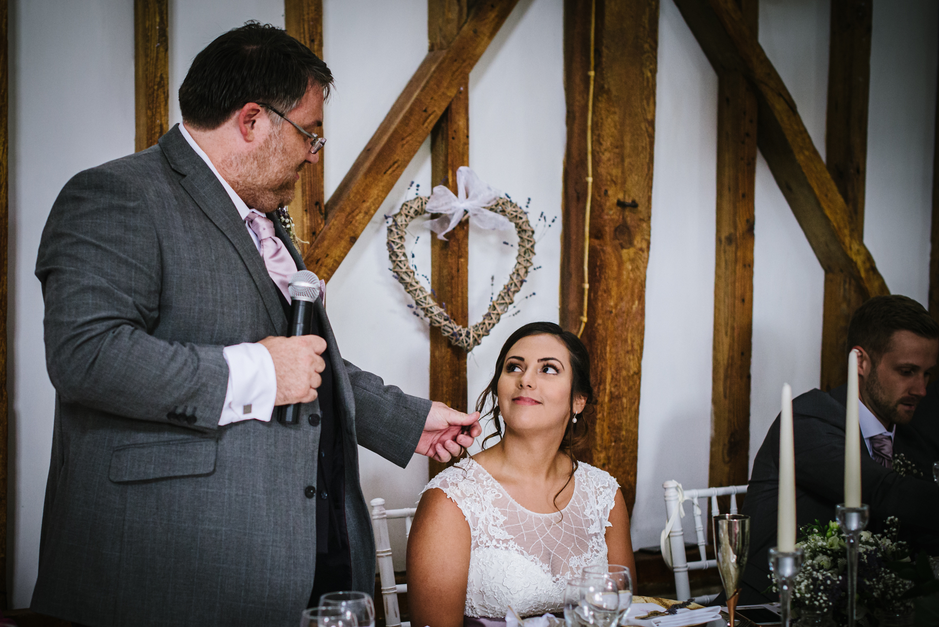 Bride looks emotional as her fathers gives his wedding speech