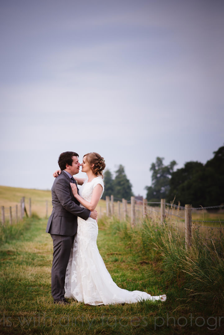 Bride and groom stand under cloudy skies at Tewin Bury Farm Hotel in Hertfordshire 