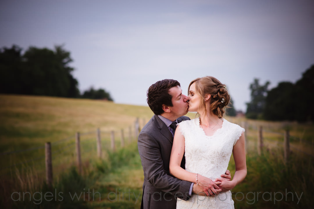 Wedding couple share a kiss at Tewin Bury Farm Hotel wedding venue