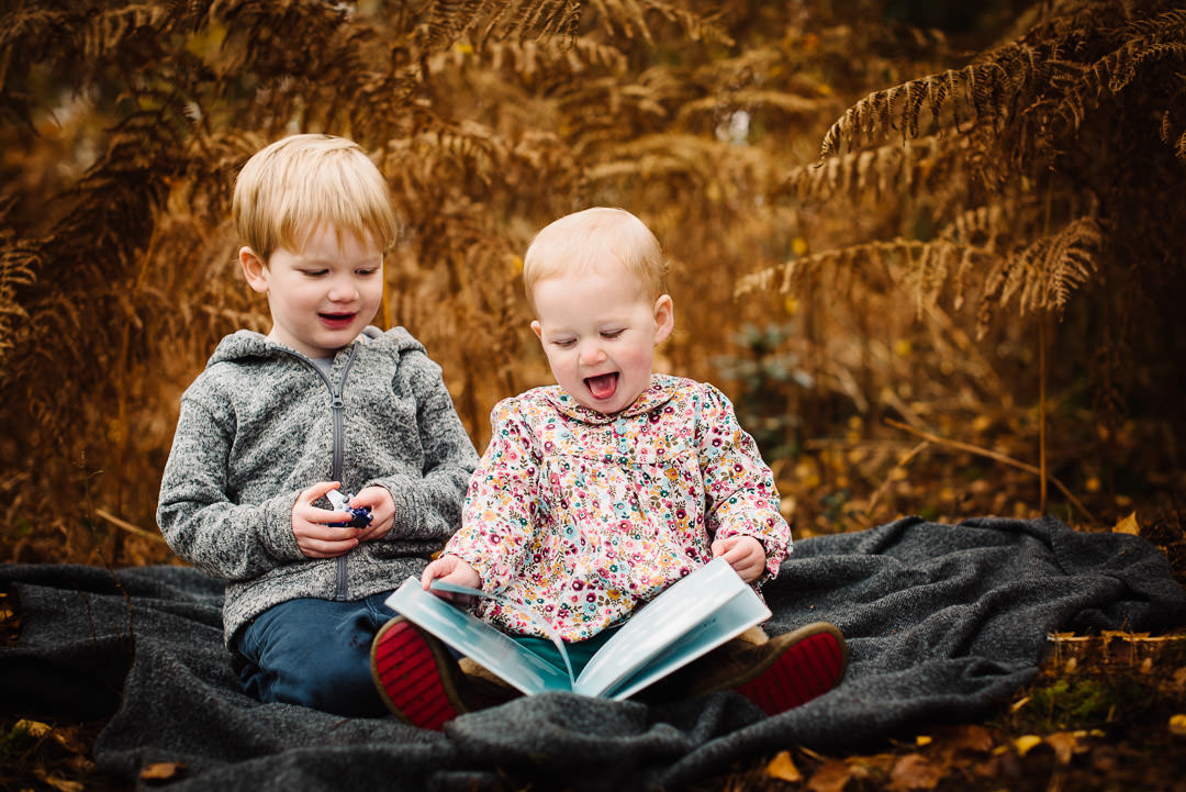 Siblings sit and enjoy a book during their Autumn photo Shoot 