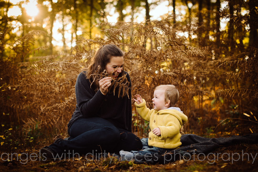 mum and child playing in autumn woods