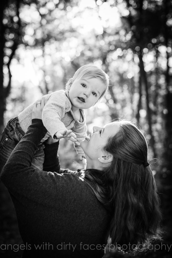 mother throwing baby in air on an autumn photo shoot