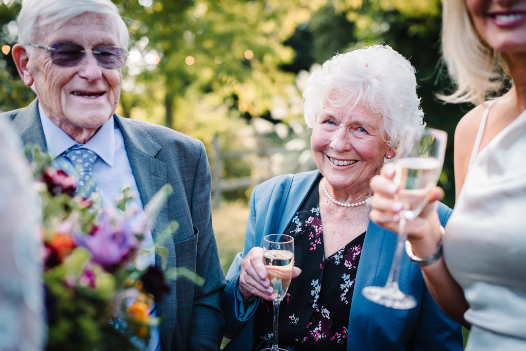 grandmother enjoying a glass of bubbly at a wedding