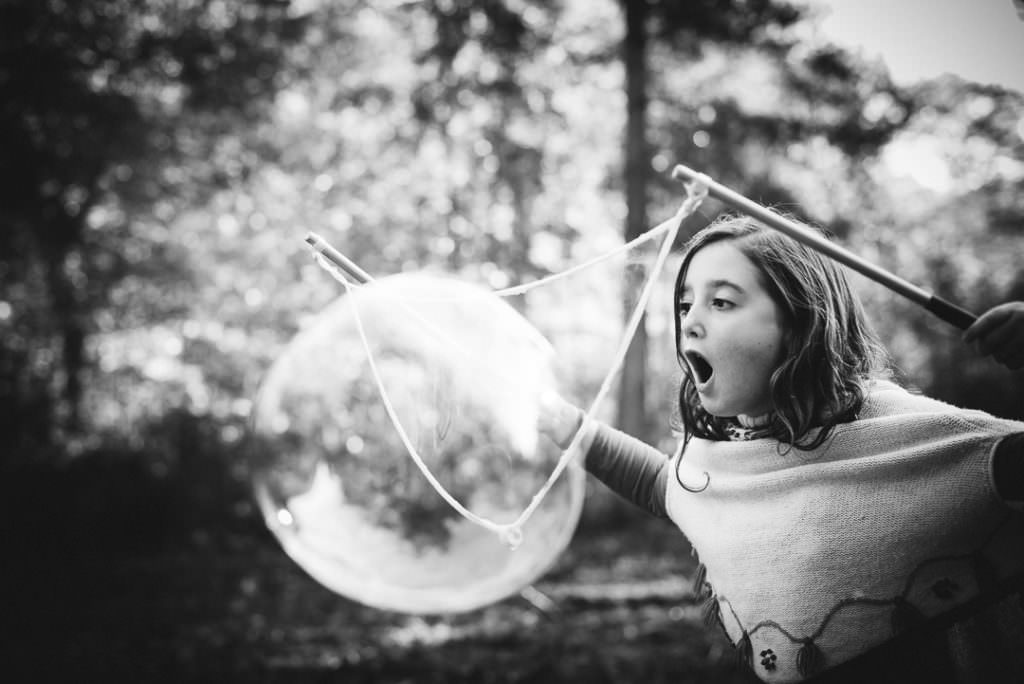 hertfordshire girl blows bubbles on her woodland photo shoot
