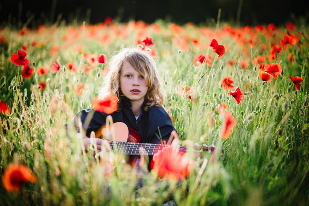 poppy portrait session with young blond boy and his guitar
