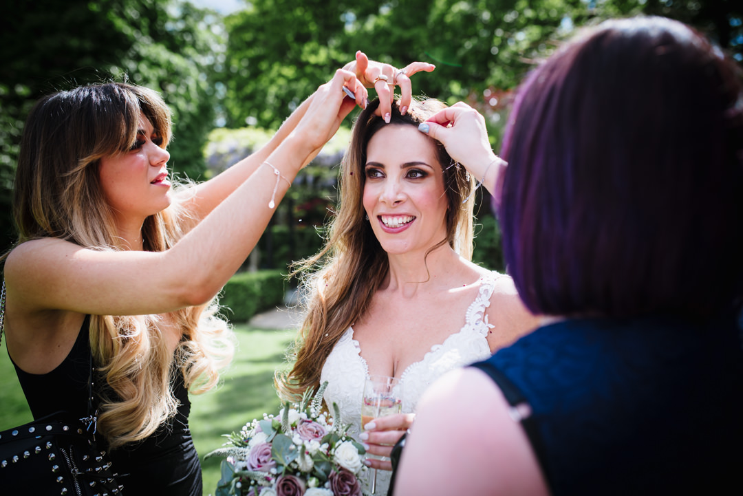 brides friends pluck confetti from her hair after the bull hotel wedding ceremony