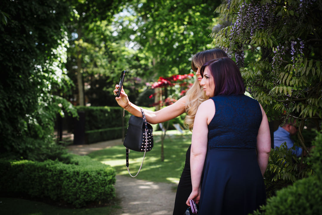 two bull hotel wedding guests take selfies in the bull hotel garden