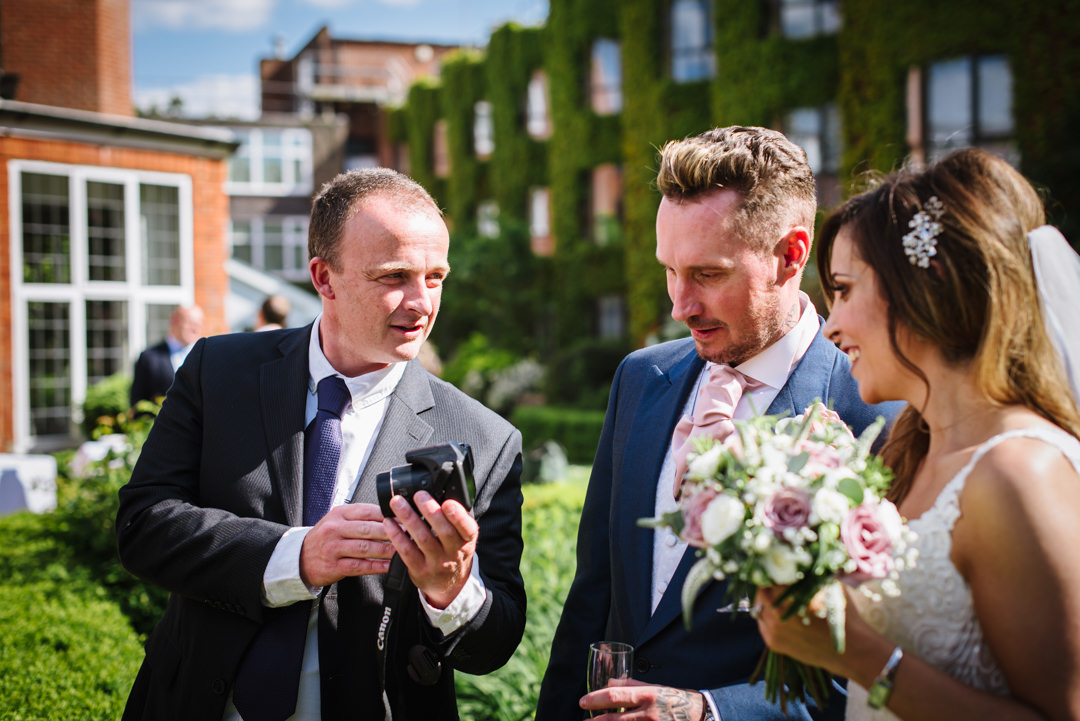 guest shows the bride and groom a photo he took of their bull hotel wedding