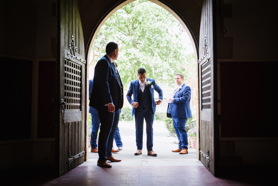 groom and groomsmen wait patiently outside church