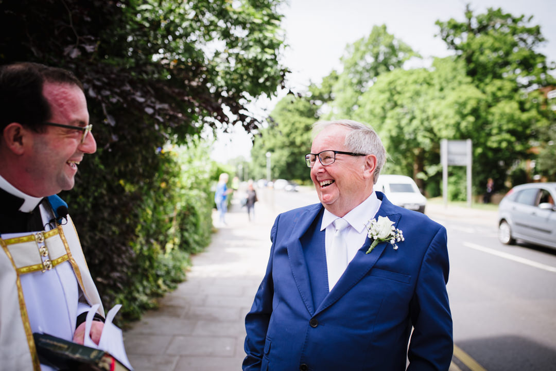 a shared joke between priest and father of the groom outside church