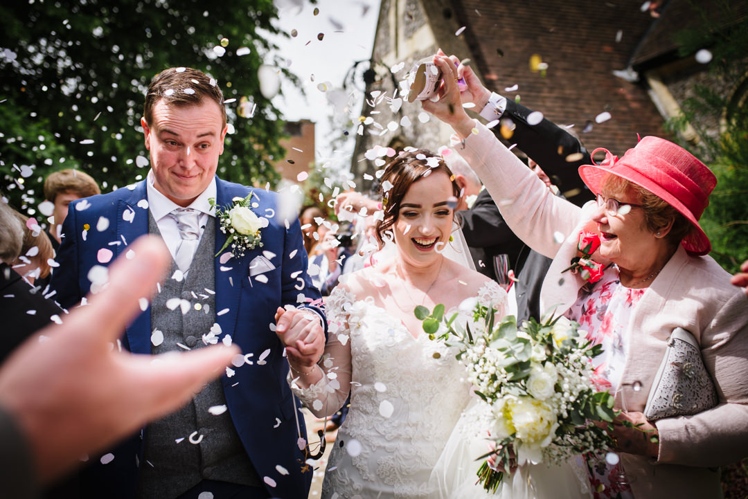 bride and groom walk under the confetti in the sunshine at essendon country club wedding