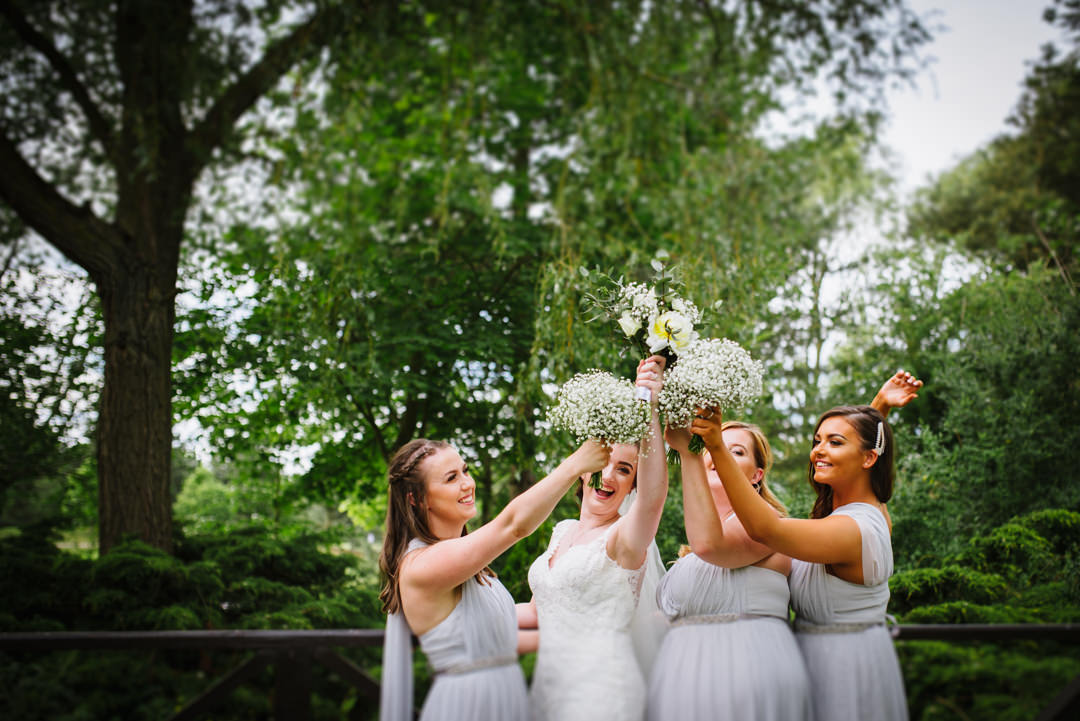 bride and her bridesmaids show off their flowers at wedding at essendon country club