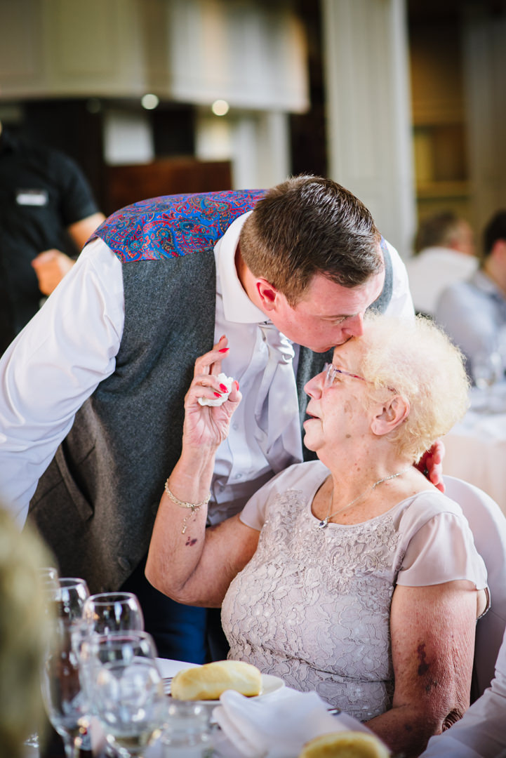 groom tenderly kissing his grandmother at the essendon country club wedding breakfast