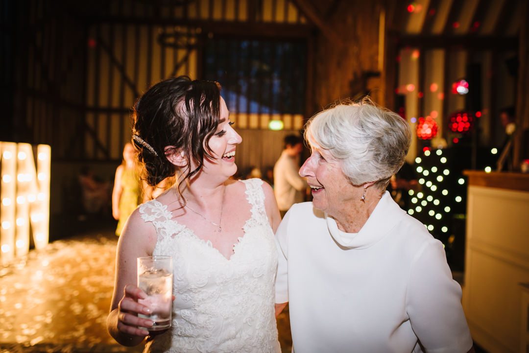 bride and her grandmother laugh together during the evening wedding celebrations at essendon country club