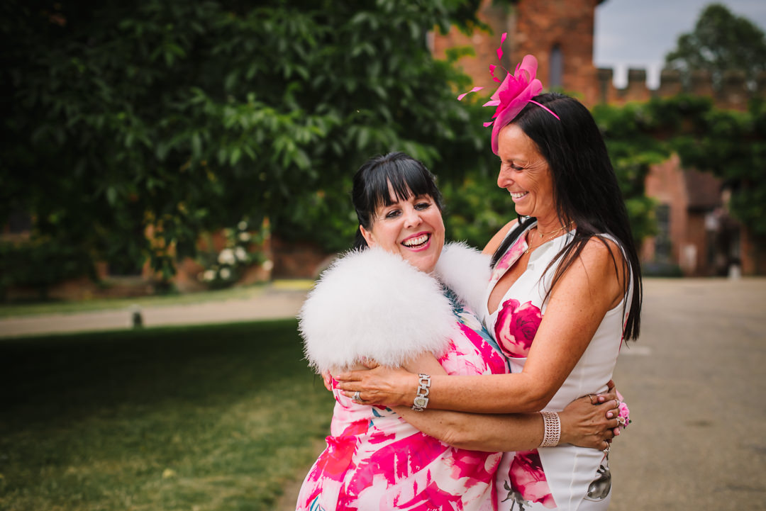 brides mum and sister have a hug all dressed in bright pink fluff