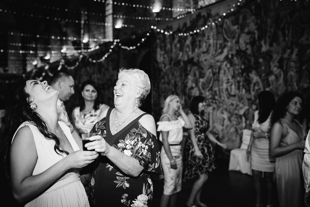 two wedding guests share a joke on the dance floor