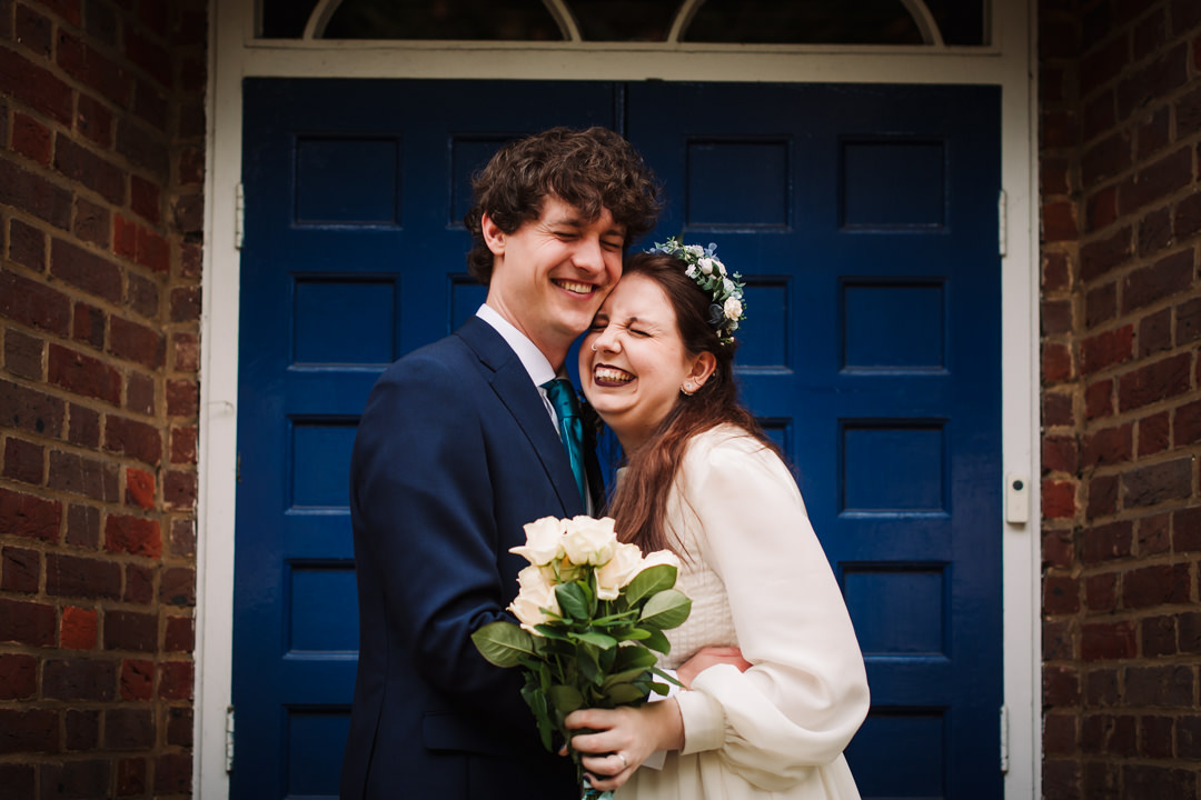 bride and groom portrait in front of old blue door of the free church in welwyn garden city