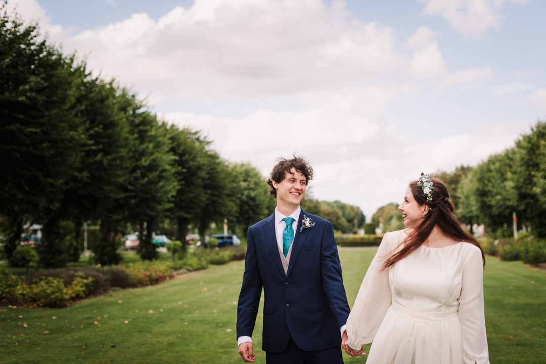 bride and groom walk along parkway in welwyn garden city