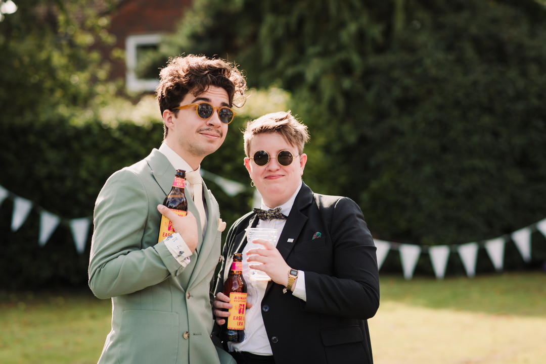 two friends pose with their beers at welwyn garden city wedding reception