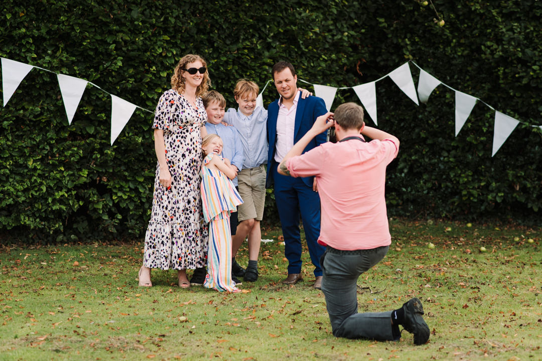 an onlooker takes family photos at welwyn garden city wedding reception