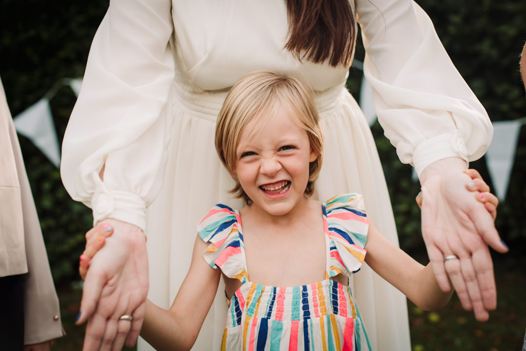 small wedding guest holds brides hand