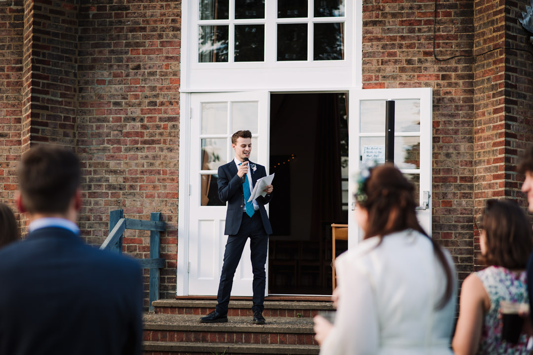 best man makes his speech on the steps of the free church welwyn garden city