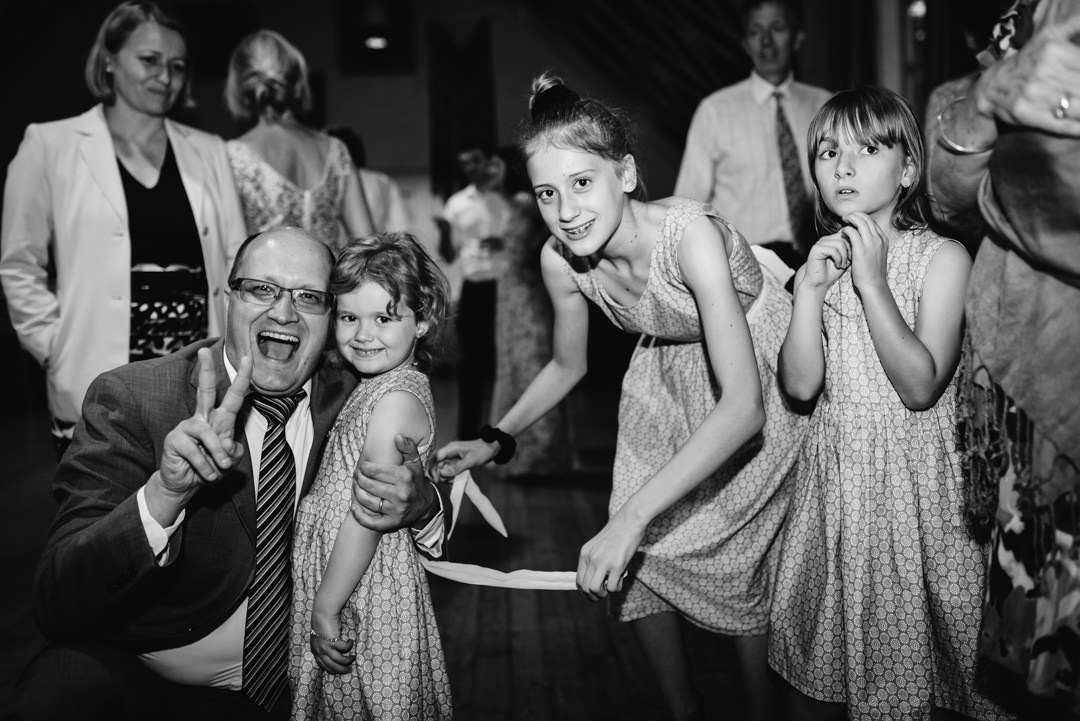 dad of three girls shows the v sign at wedding reception party