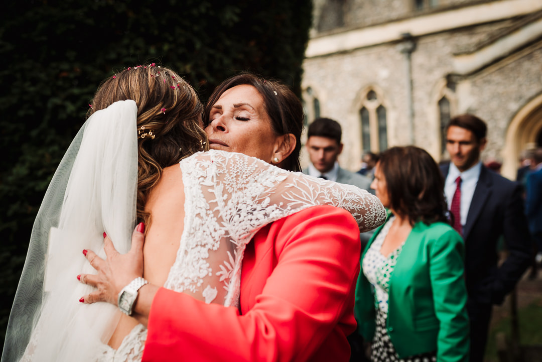 warm welcome from wedding guests as the hug the bride at micklefield hall