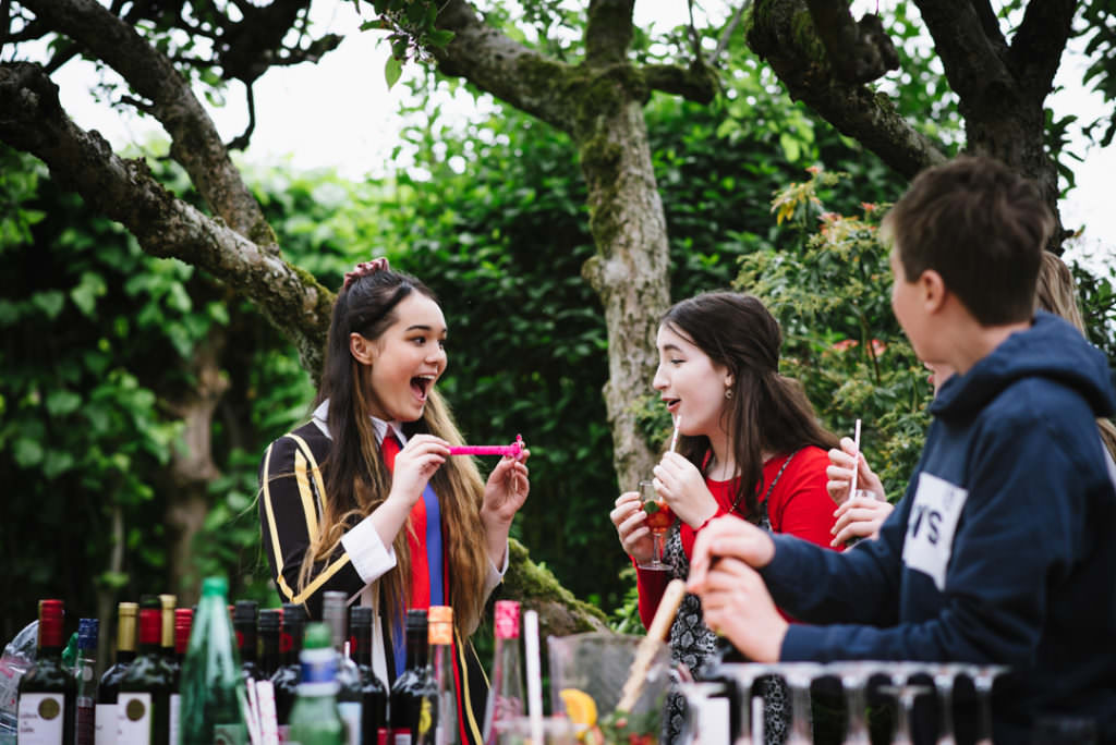 teenage party guests joke at the bar in garden 