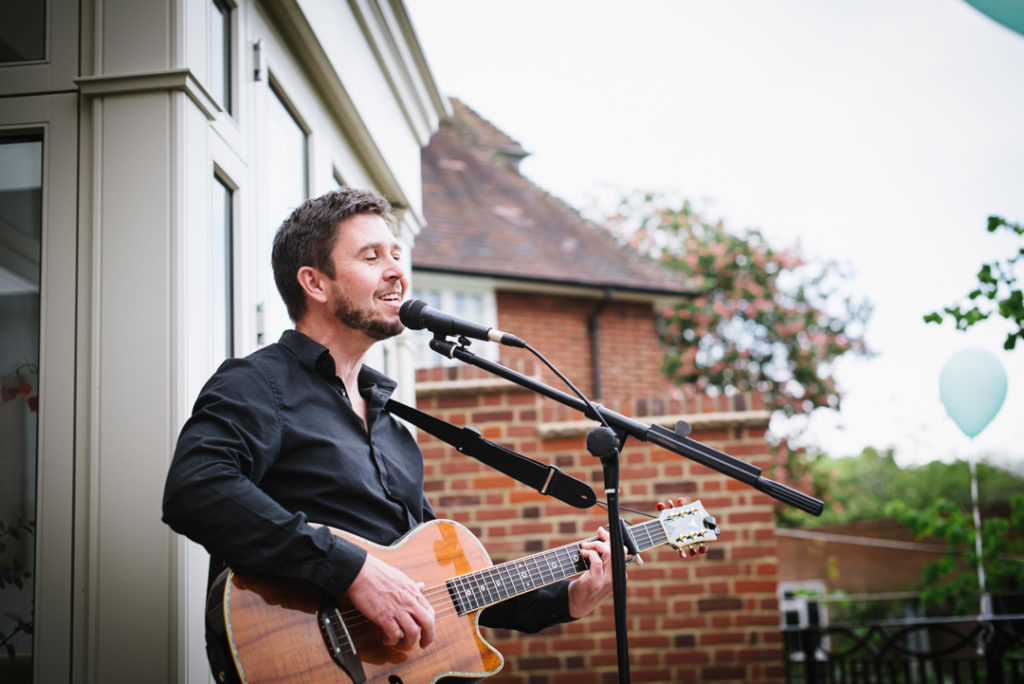 acoustic guitar player sings at hertfordshire party