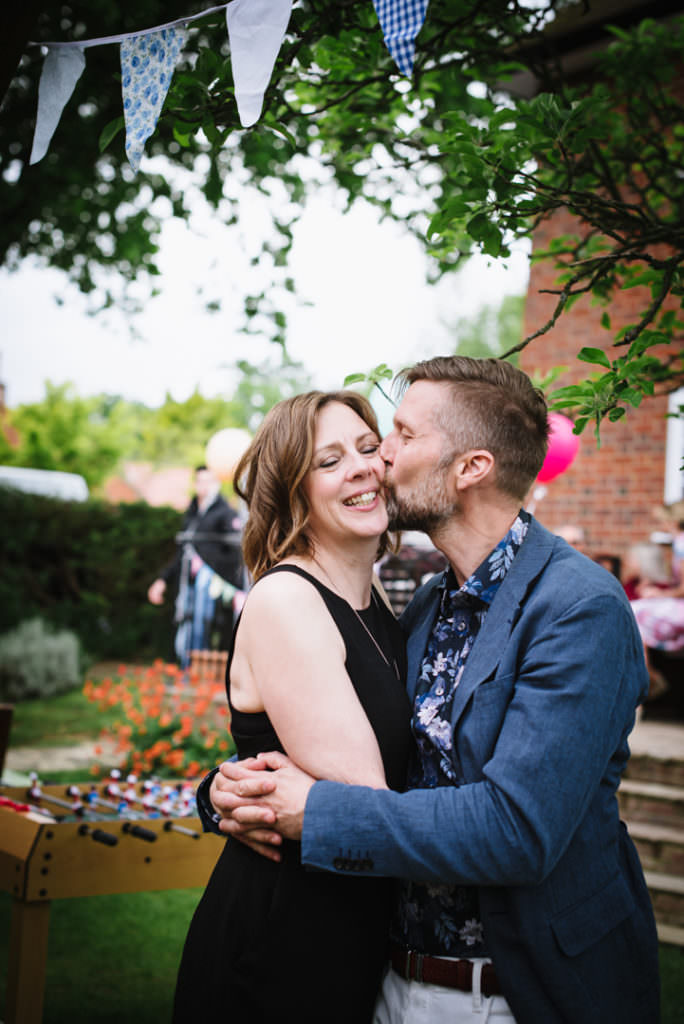 couple at a party kiss for the hertfordshire party photographer