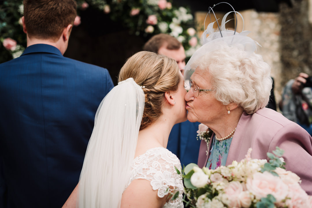 brides grandmother fondly kisses her cheek after the harpenden wedding ceremony