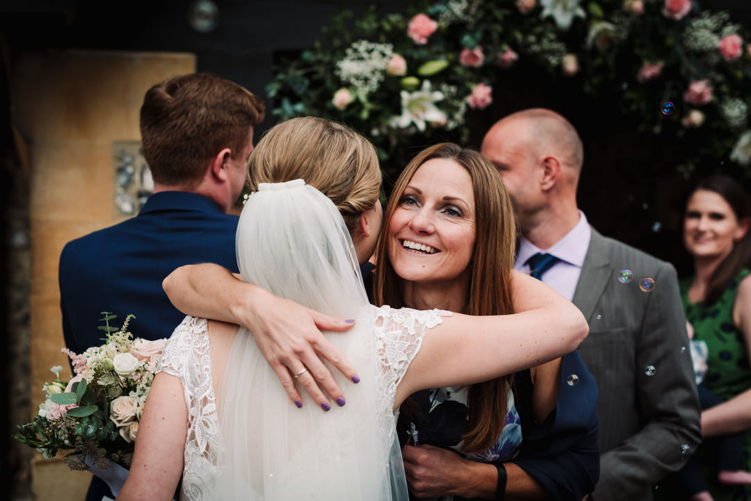 guest and bride hug warmly for a photo by their harpenden wedding photographer