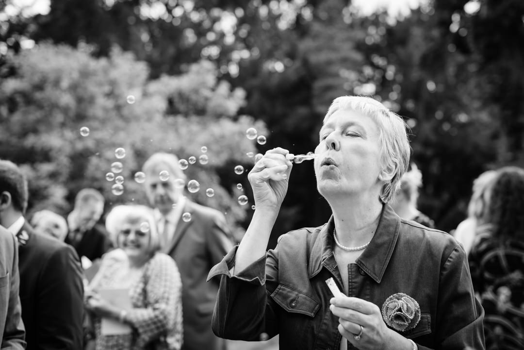 guests blow bubbles after the wedding ceremony