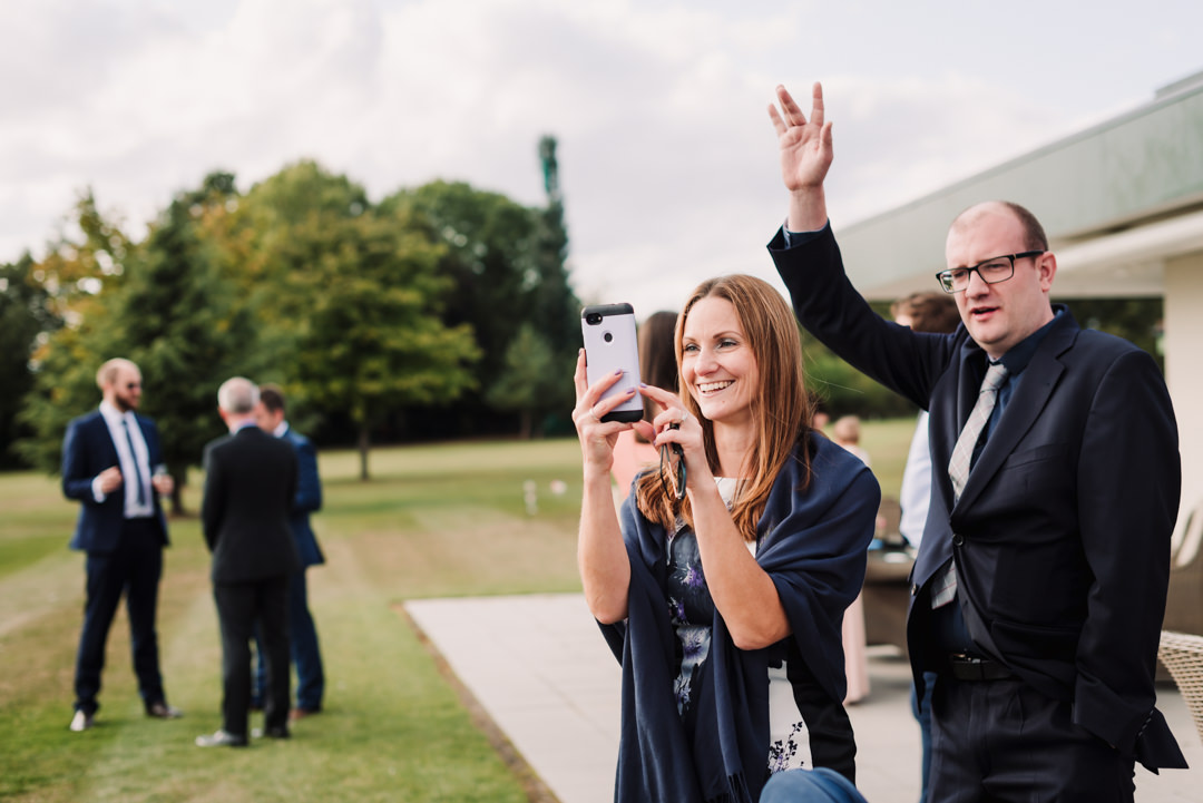 harpenden wedding guests wave at each other